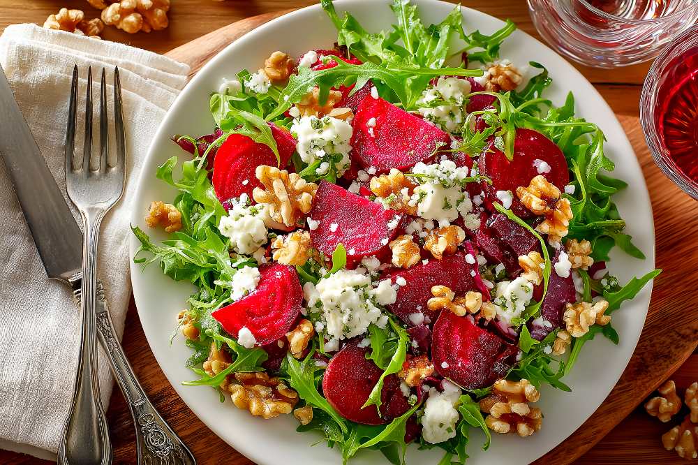 Beetroot Salad with Arugula, Walnuts and Blue Cheese Crumbles, in a white plate