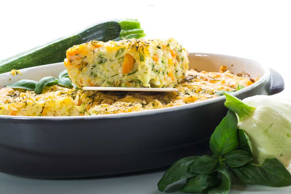 Casserole of Patissons, Zucchini and Carrots serve in a baking dish with Zucchini on the side
