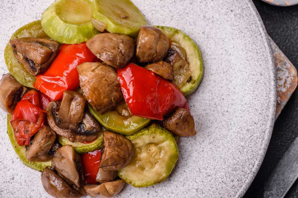 Pan-Grilled Vegetables mushroom, zucchini and red peppererve in a rastic plate