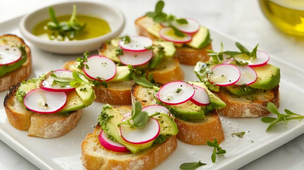 bruschetta with slice avocado and radish . served on a white platter with side ofolive oil