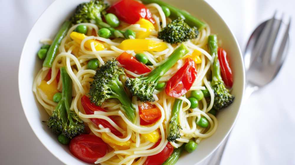 Vegetable Pasta Bowl with Broccoli Cherry Tomatoes and Green Peas, serve in a white bowl , close-up top view