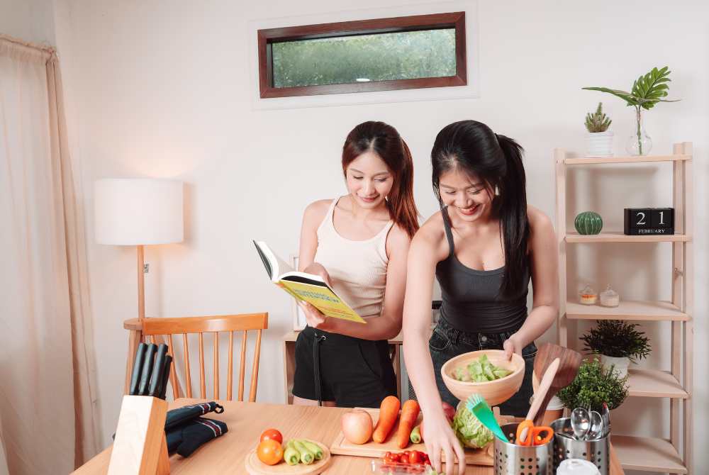 Cooking with Friends A Guide to Healthy Meals Together, standing over a kitchen table.