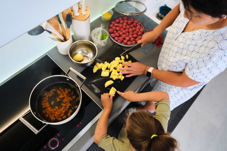 Grandmother and granddaughter are preparing soup. in a kitchen setting , top view.