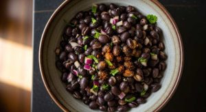 black beans with onions and herbs, serve in a rustic bowl , close-up top view.