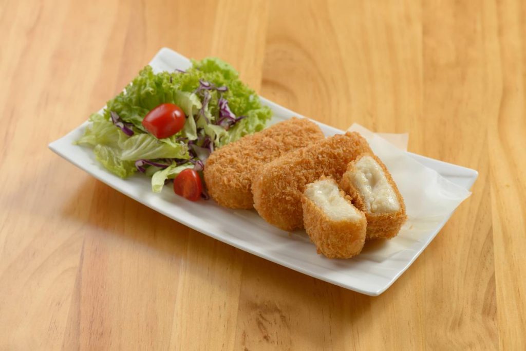 japanese Kani Korokke with tomato and salad in white tray on wooden background, close up top view